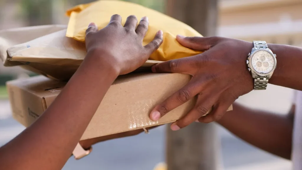 Encomenda embalada sendo entregue de uma pessoa para outra no balcao