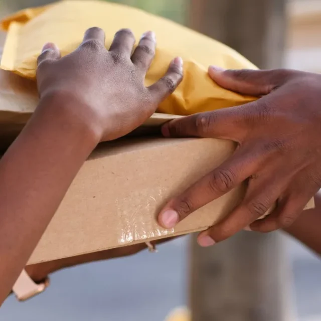 Encomenda embalada sendo entregue de uma pessoa para outra no balcao