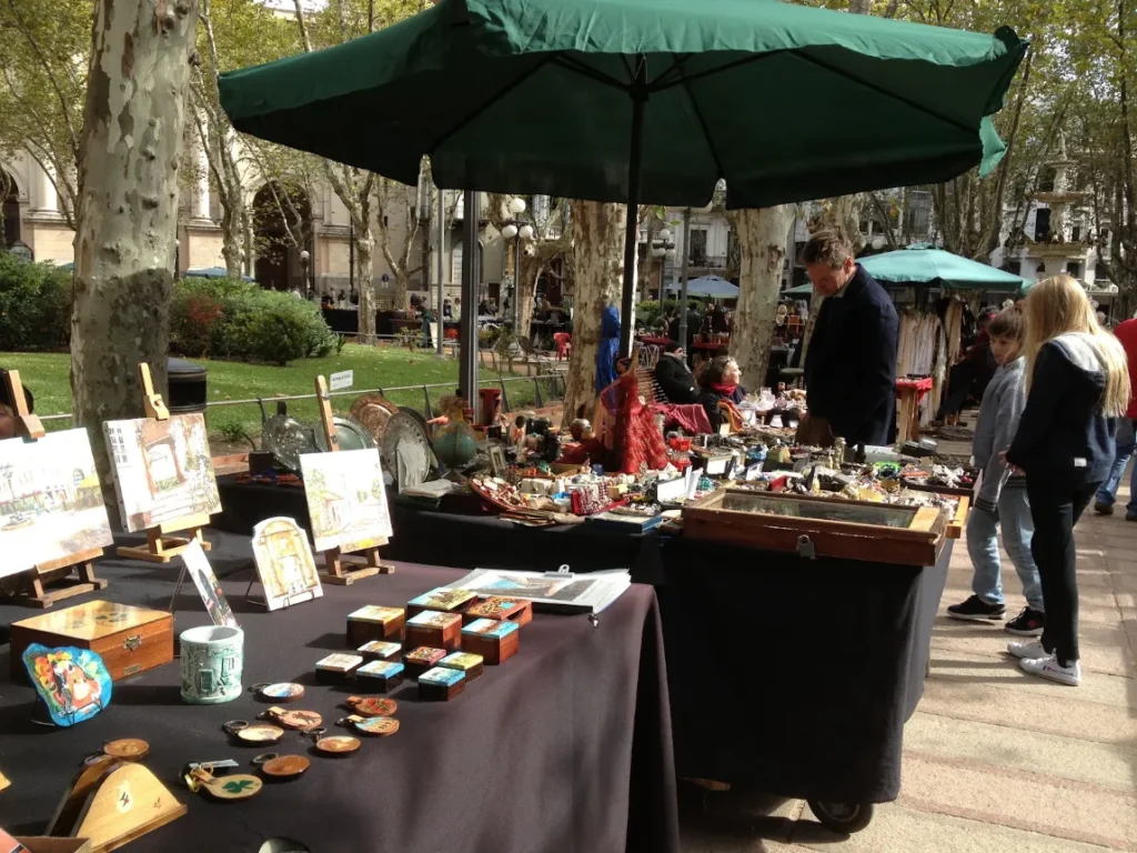 Banca da feira de antiguidades montada sob as arvores da Plaza de la Constitucion