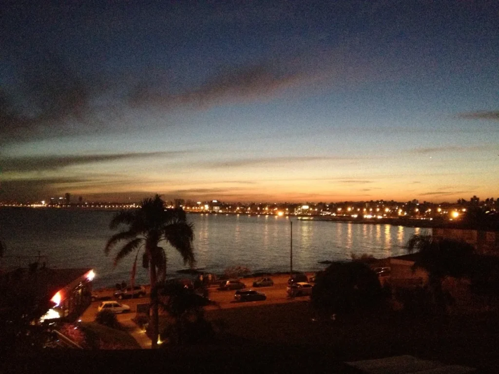 Fim de tarde na costa uruguaia, com as luzes da cidade acendendo