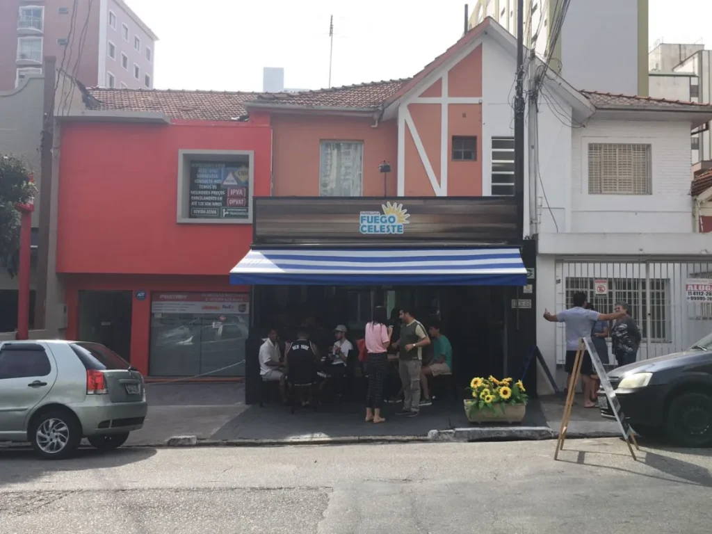Chorizos, batatas e cortes de carne assando na parrilla do Fuego Celeste