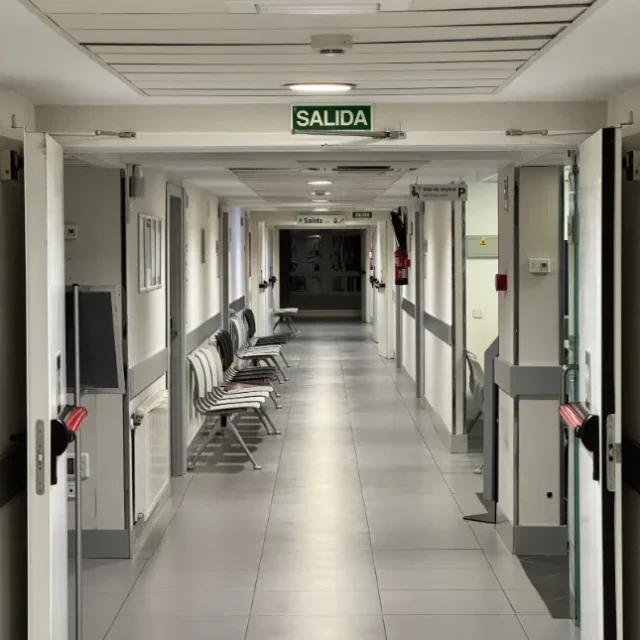 Corredor de hospital com placa de saida