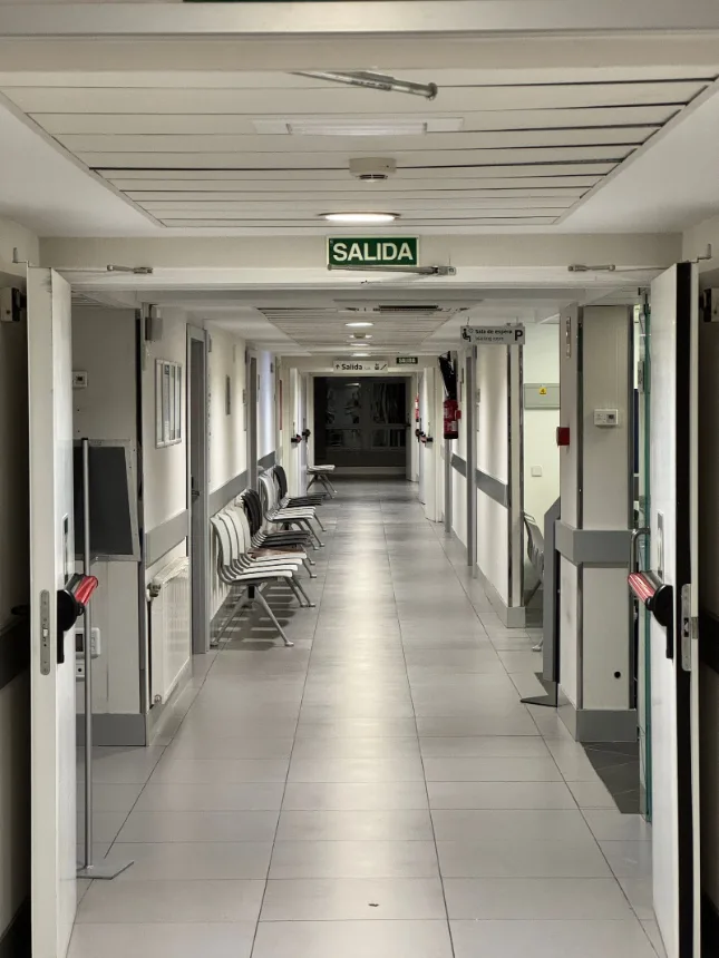 Corredor de hospital com placa de saida