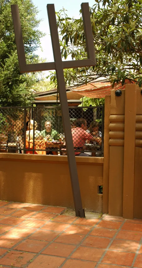 Area externa arborizada do restaurante com mesas ocupadas por clientes