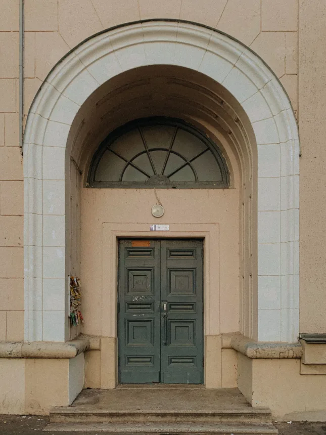 Portal em arco com porta de madeira em um edificio antigo