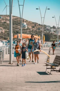 Família caminhando com crianças pelo calçadão à beira-mar