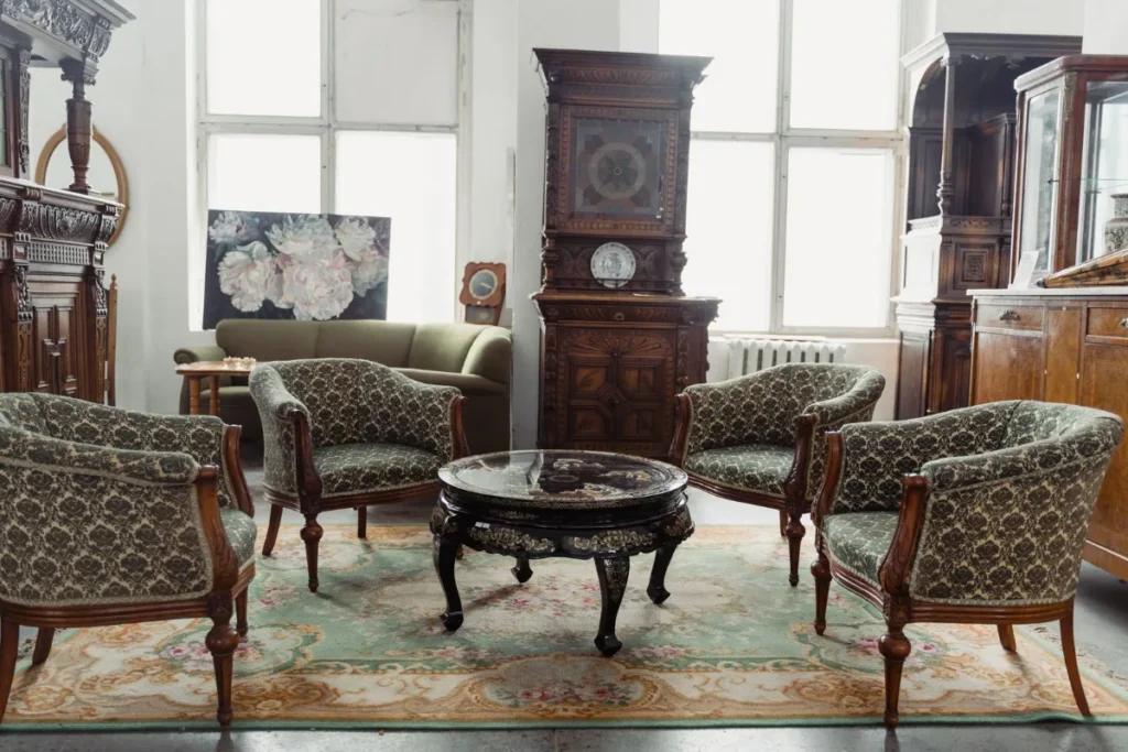 Sala com poltronas, relogio de pendulo e mobiliario de epoca