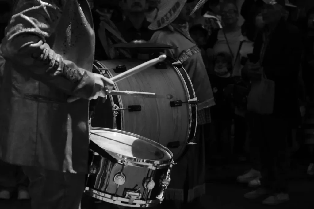 Percussionista de rua tocando bumbo e prato, em preto e branco