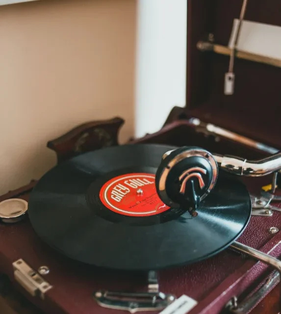 Gramofone antigo com disco de vinil sobre movel de madeira
