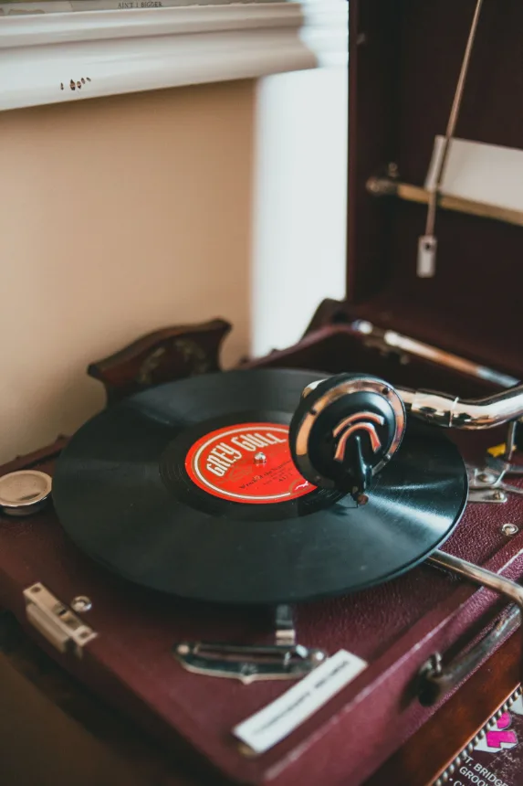 Gramofone antigo com disco de vinil sobre movel de madeira