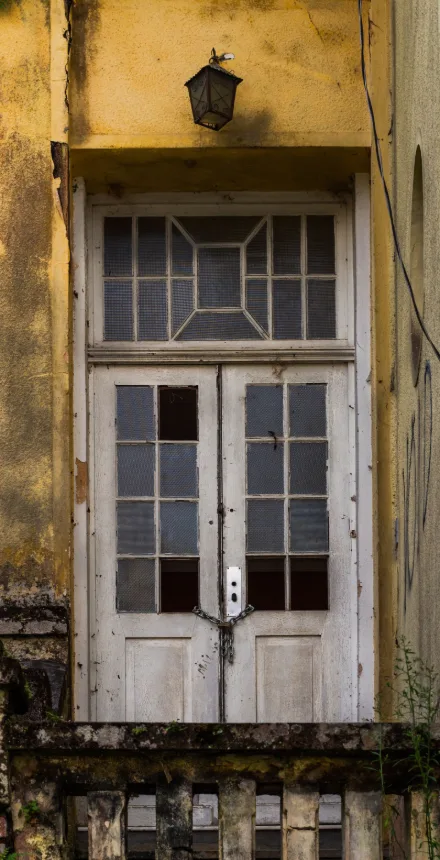 Portas duplas de madeira antigas e fechadas em fachada histórica