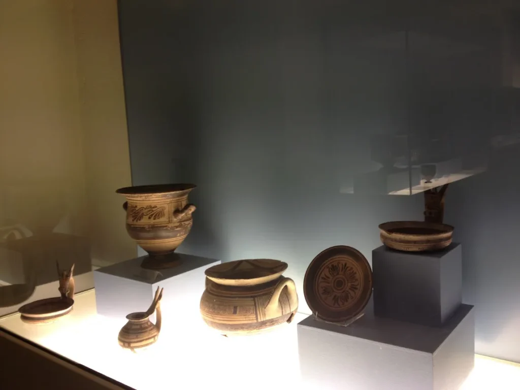 Vasos e pecas de ceramica antiga expostos em vitrine iluminada do museu