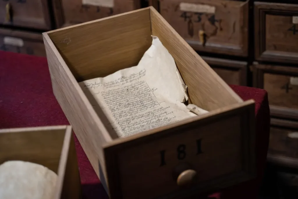 Caixa de arquivo aberta com documento manuscrito antigo