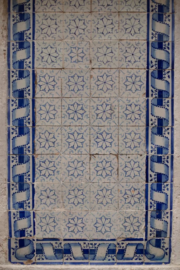 Parede de azulejos com padrão de estrelas azuis e faixa decorativa