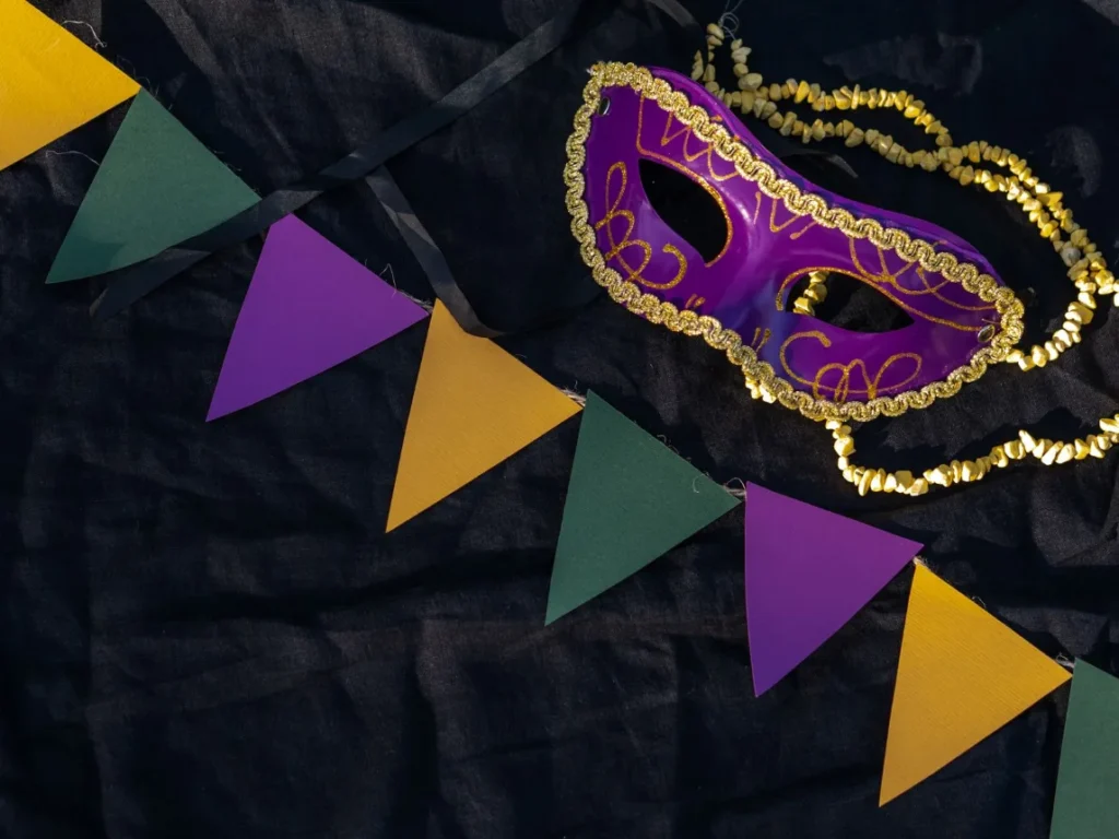 Mascara de carnaval decorada e bandeirinhas coloridas sobre fundo escuro