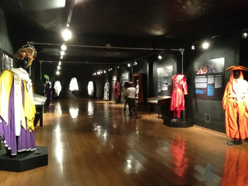 Sala de exposicao do Museu do Carnaval com fantasias alinhadas ao longo do corredor