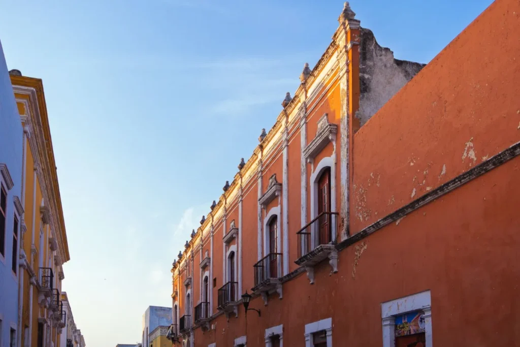 Casario colonial de fachada laranja com sacadas de ferro