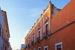 Casario colonial de fachada laranja com sacadas de ferro