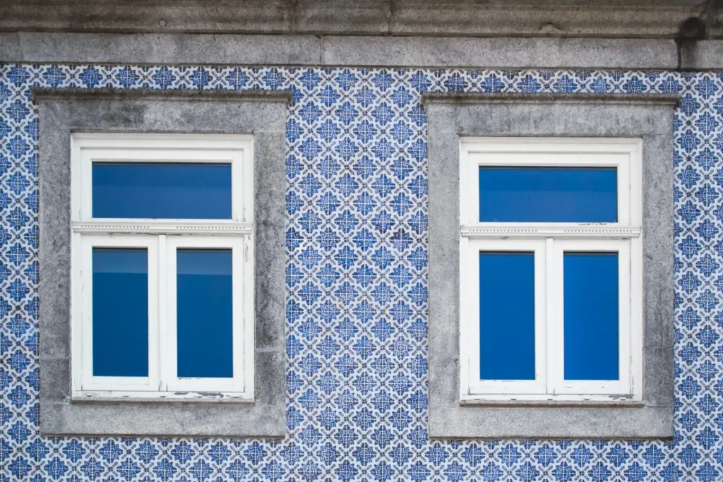 Fachada revestida de azulejos azuis e brancos com janelas antigas