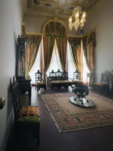 Salao de uma casa do seculo XIX com moveis antigos, tapete e lustre