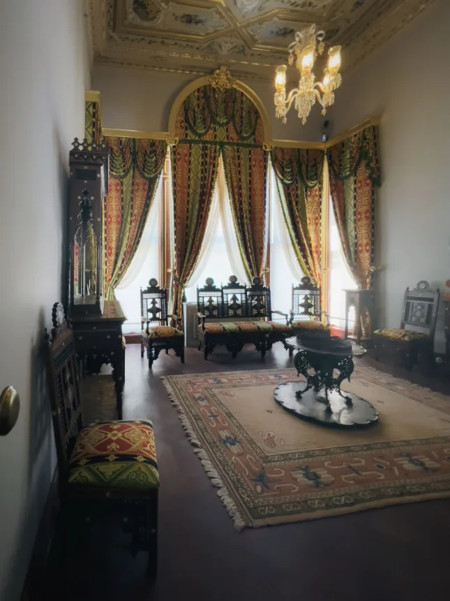 Salao de uma casa do seculo XIX com moveis antigos, tapete e lustre