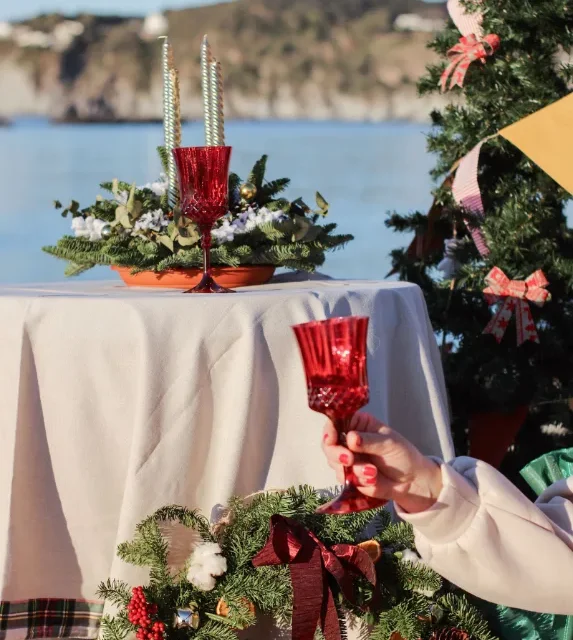 Mesa de ceia de Natal montada ao ar livre à beira da água