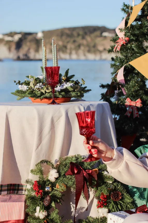 Mesa de ceia de Natal montada ao ar livre à beira da água