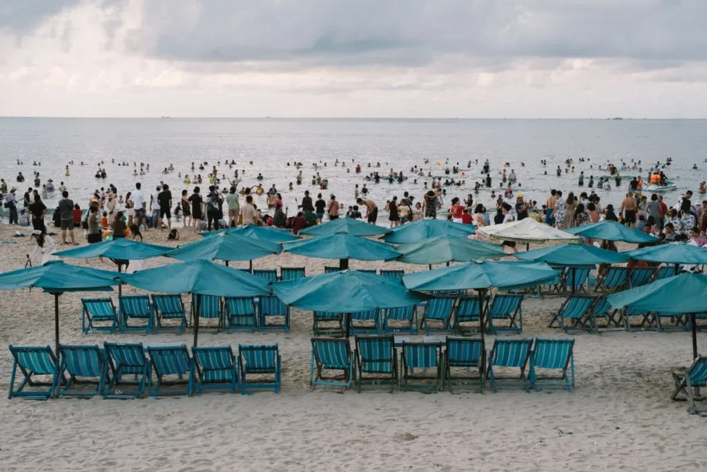 Praia lotada de guarda-sóis e banhistas no verão