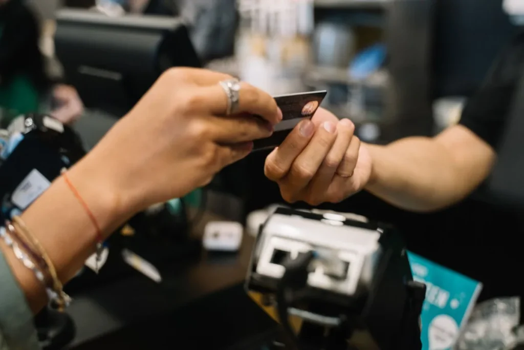 Viajante atravessando a rua com mala de rodinhas e mochila nas costas