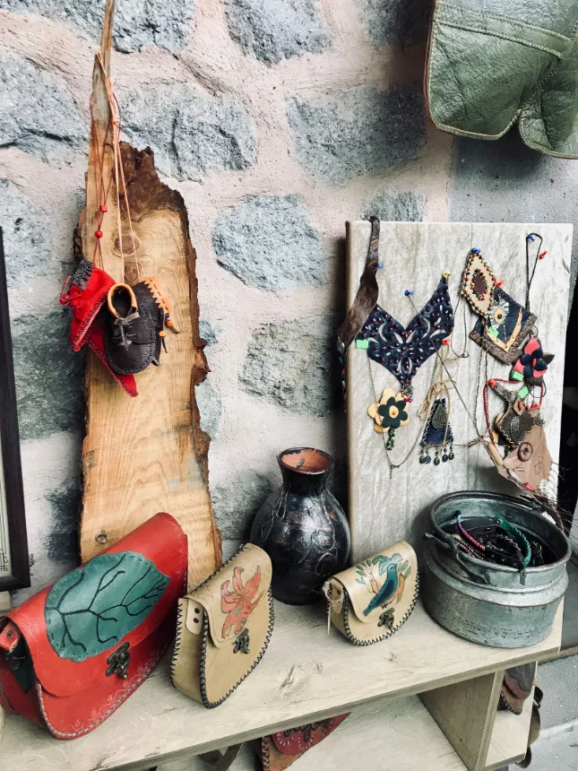 Bolsas e objetos de couro artesanais expostos sobre uma bancada