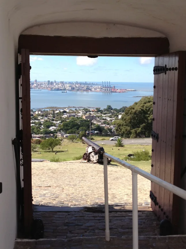 Montevideo vista pela porta da fortaleza, com um canhão em primeiro plano