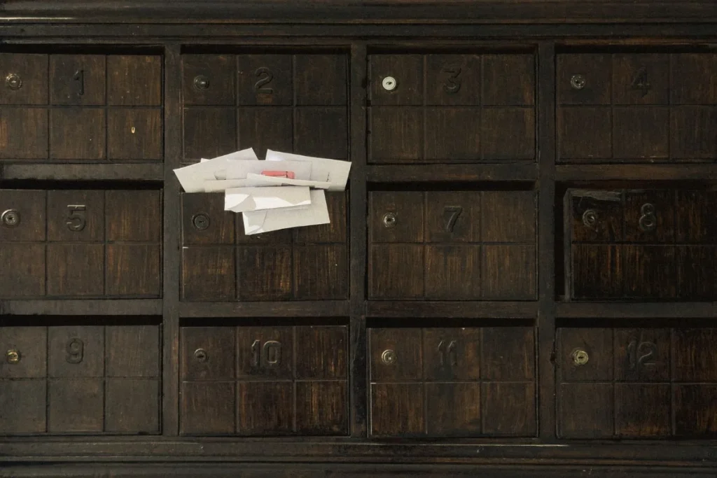 Caixa de correio antiga de madeira com escaninhos numerados e cartas