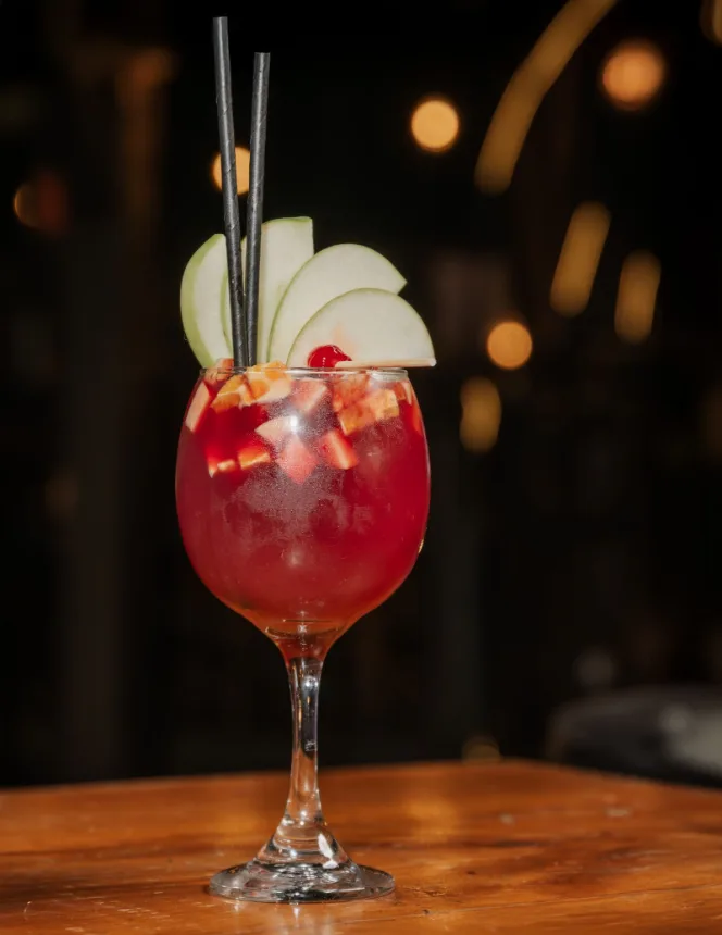 Taca de bebida gelada com frutas sobre a mesa de um bar