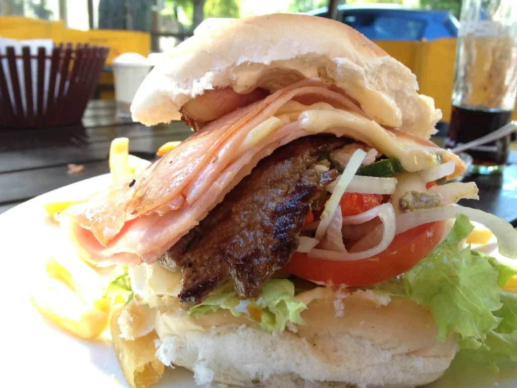 Chivito montado com presunto, queijo, tomate e alface visto de perto