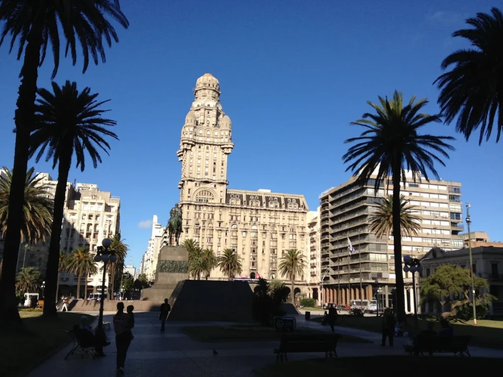 Palacio Salvo visto da Plaza Independencia, em Montevideo, com palmeiras em primeiro plano