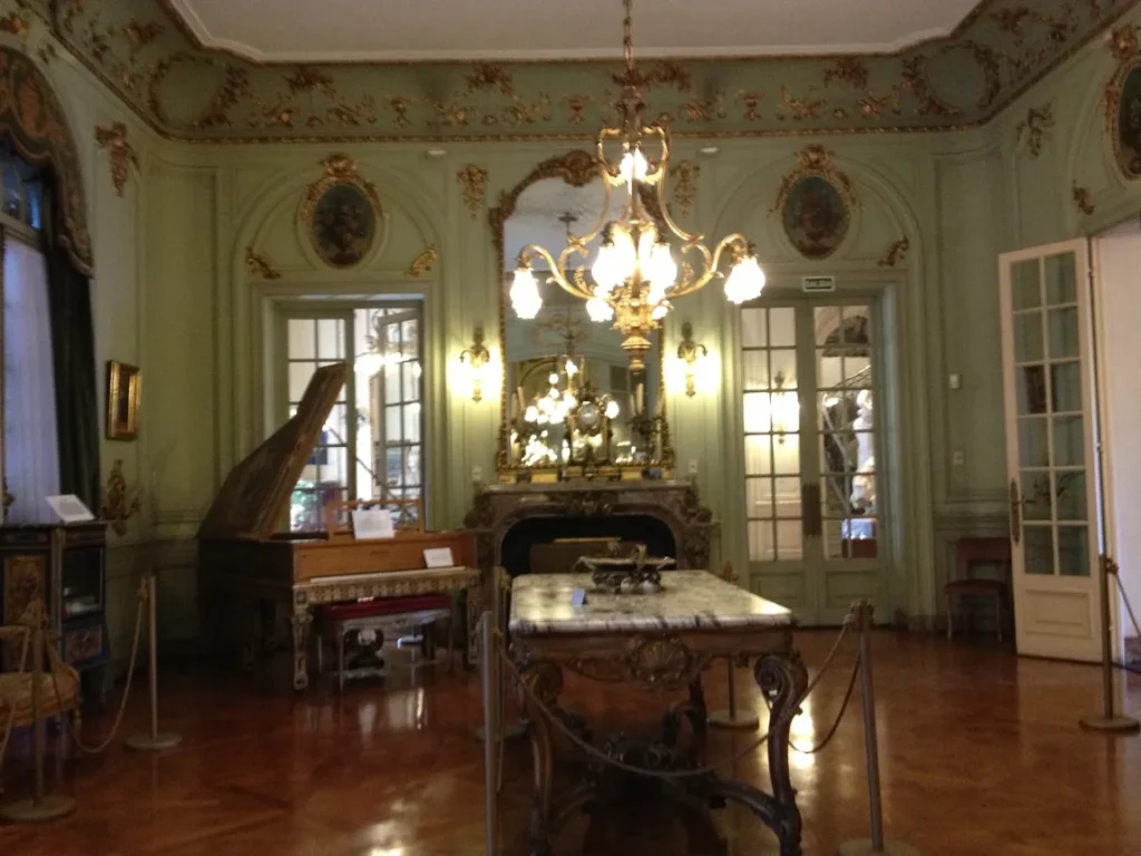 Sala de estar do Palacio Taranco com lareira, espelho e mobiliario de epoca