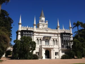 Edificio branco de estilo neogotico cercado por arvores no Parque del Prado