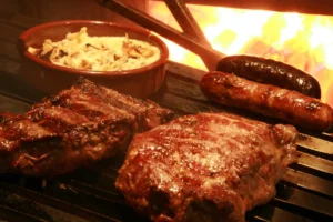 Costela, chorizos e provoleta na grelha ao lado do fogo