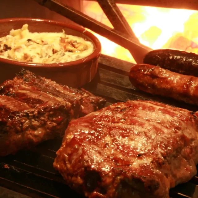 Costela, chorizos e provoleta na grelha ao lado do fogo