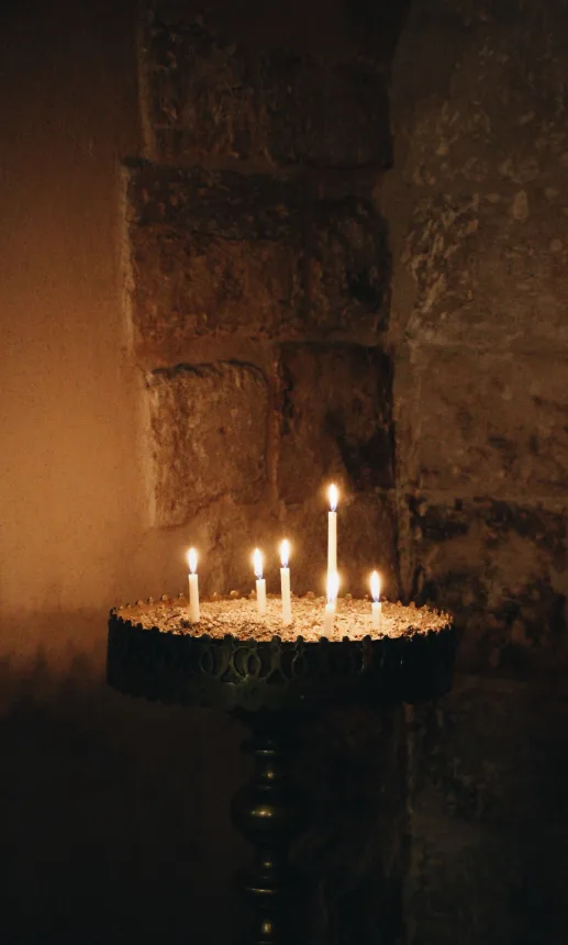Velas acesas no interior de uma igreja de pedra durante a Semana Santa