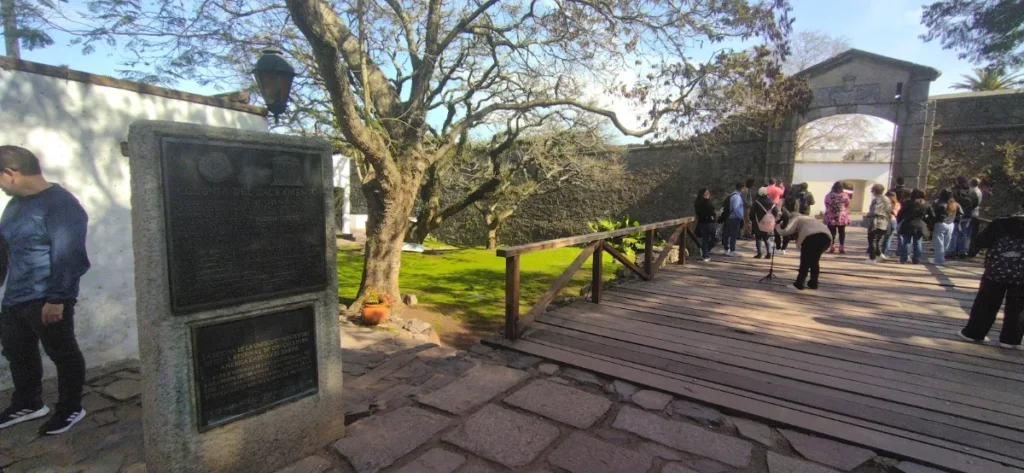 Ponte de madeira sobre o fosso, ao lado da muralha e de uma árvore antiga