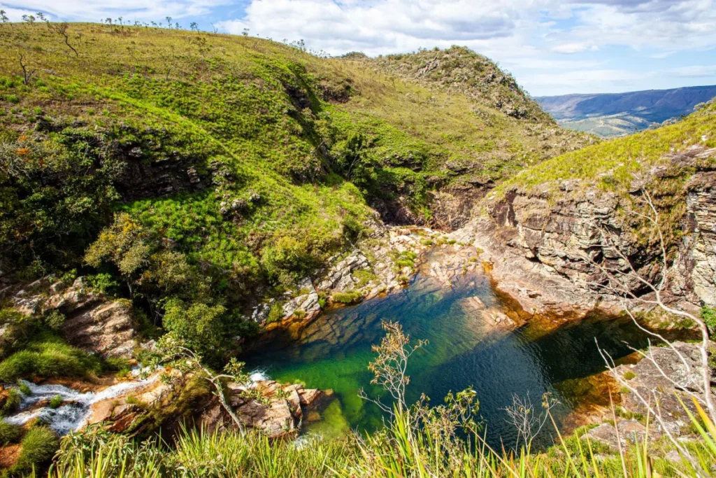 Poço natural de água esverdeada encaixado entre as encostas da serra