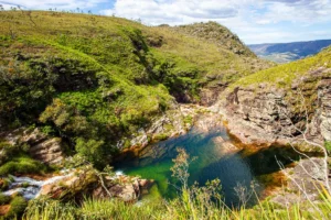 Poço natural de água esverdeada encaixado entre as encostas da serra