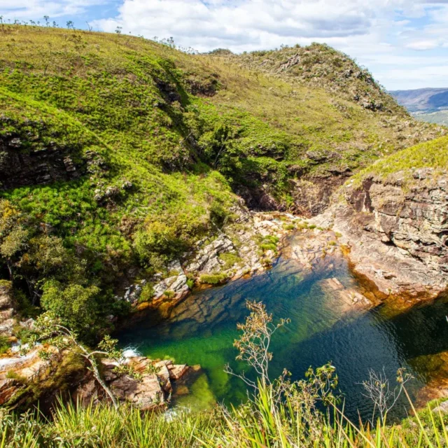 Poço natural de água esverdeada encaixado entre as encostas da serra
