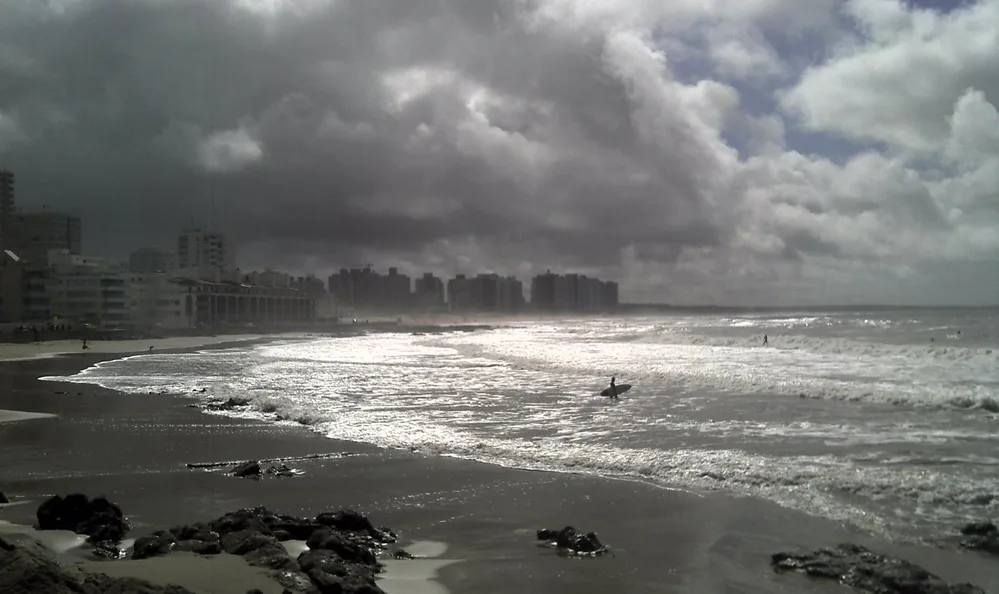 Surfistas na Praia Brava de Punta del Este sob céu carregado