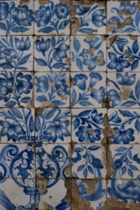 Azulejos antigos com pintura floral azul e superfície craquelada