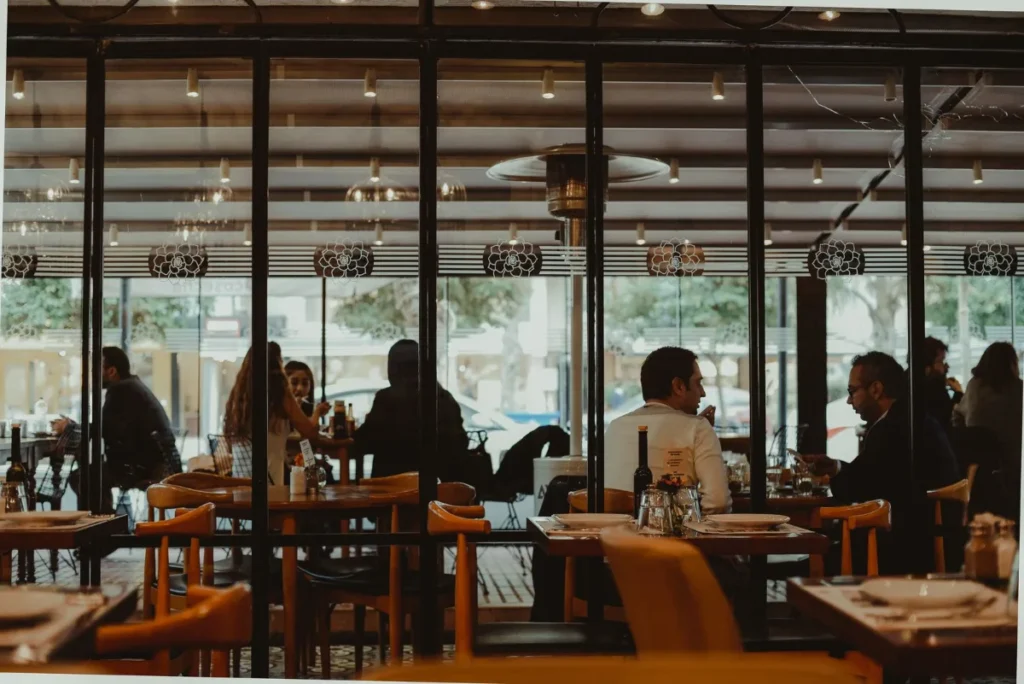 Salao de restaurante com mesas ocupadas por clientes durante a refeicao