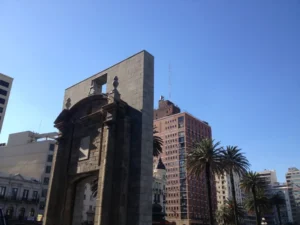 Puerta de la Ciudadela em Montevideo, com os predios do centro e palmeiras ao fundo