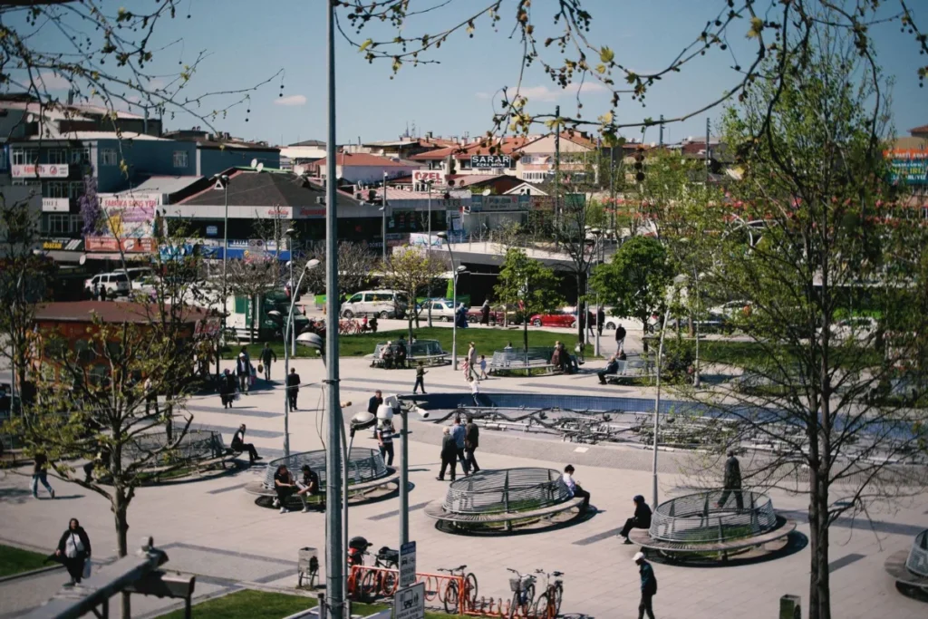 Praca urbana movimentada com pessoas caminhando e sentadas