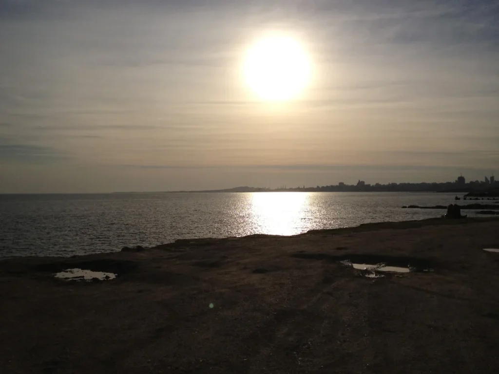 Sol baixo refletindo no Rio da Prata visto da Rambla de Montevideo